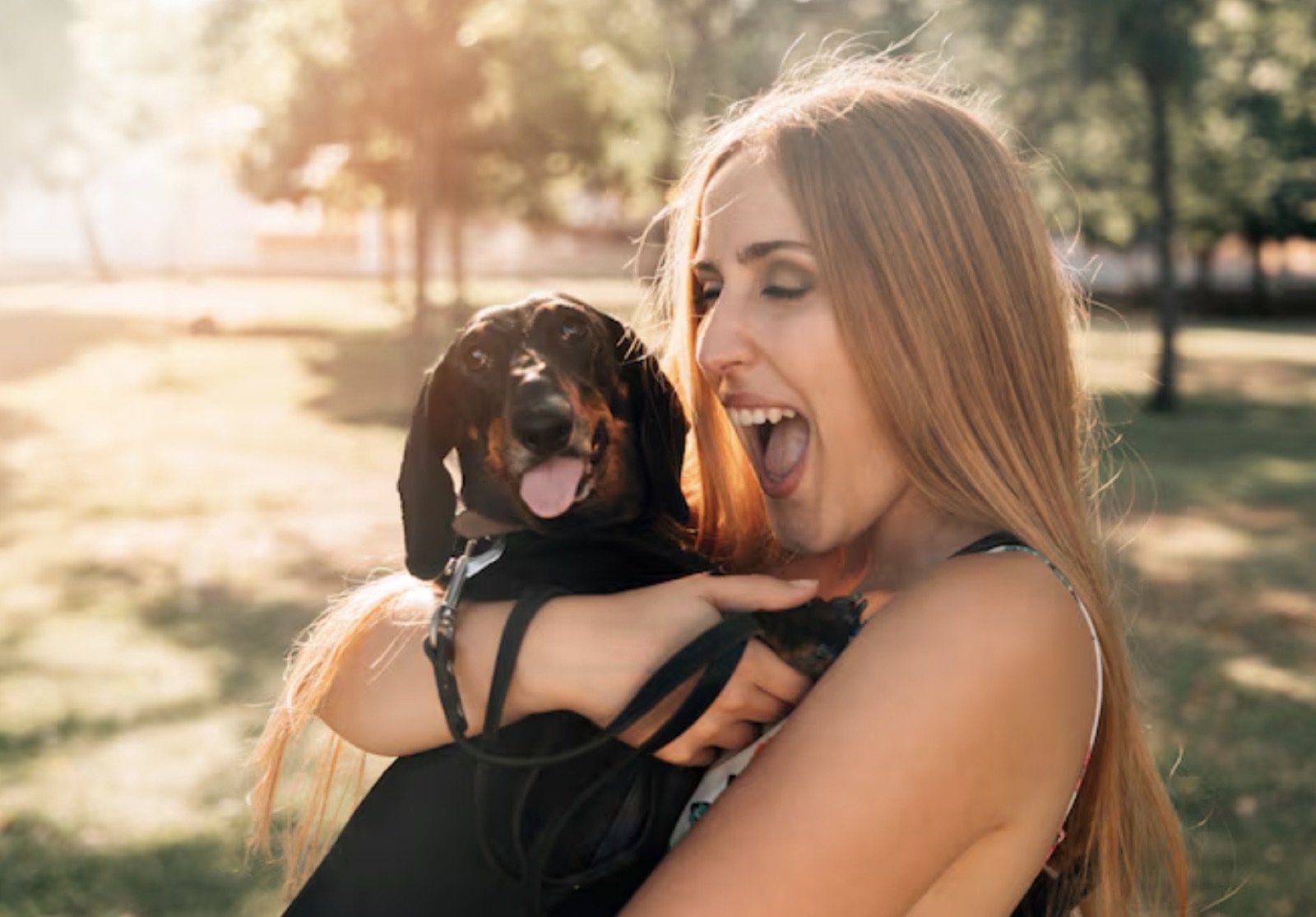 Woman hugging a small black dog